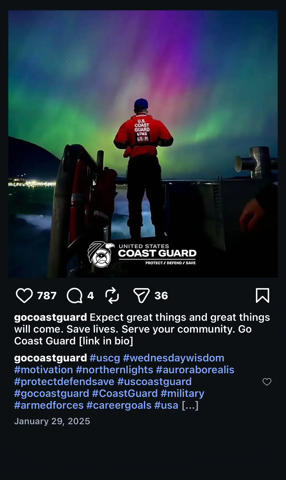 Coast Guard member in red vest showing back while looking at the Northern Lights